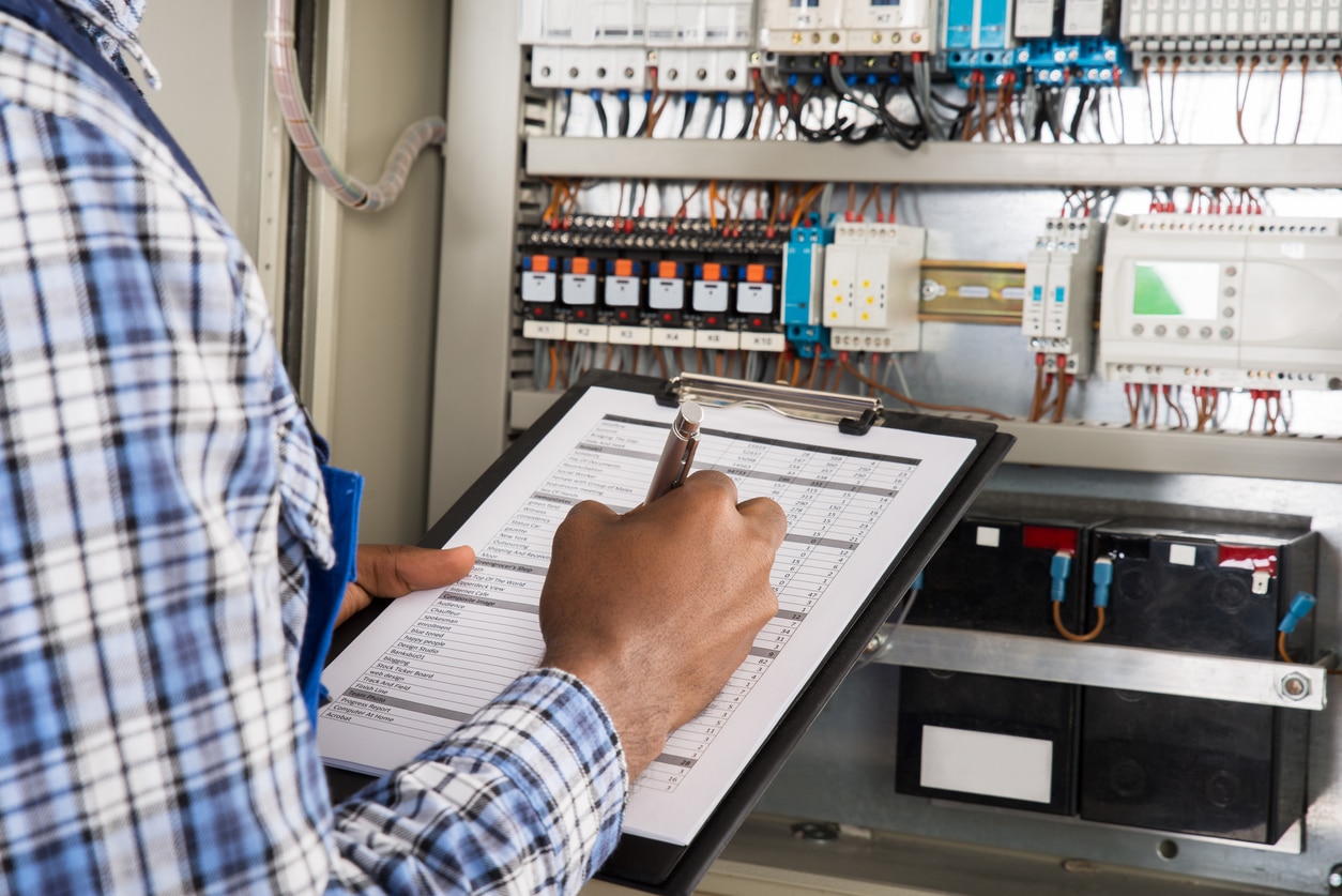 Electrician performing commercial electrical inspection to make sure that property is safe from electrical issues.